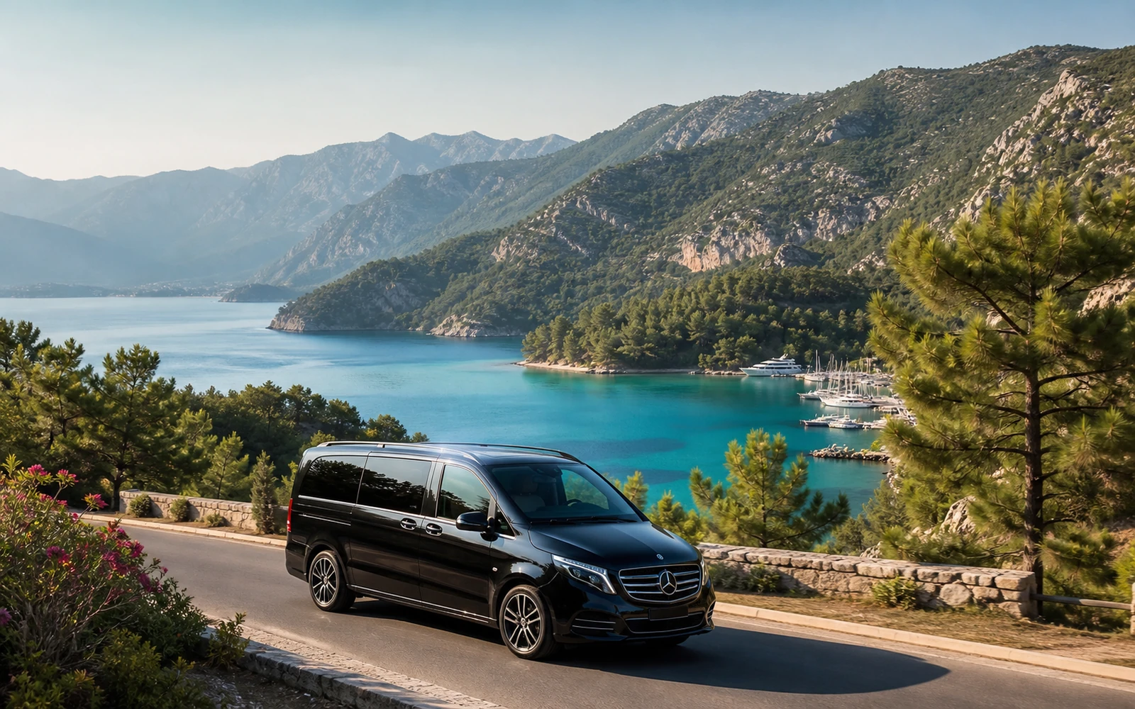 Private Dalaman Airport transfer vehicle beside a turquoise coastal bay